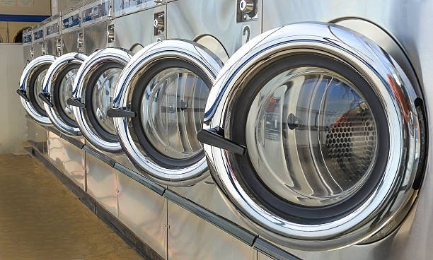 Row of industrial laundry machines in laundromat